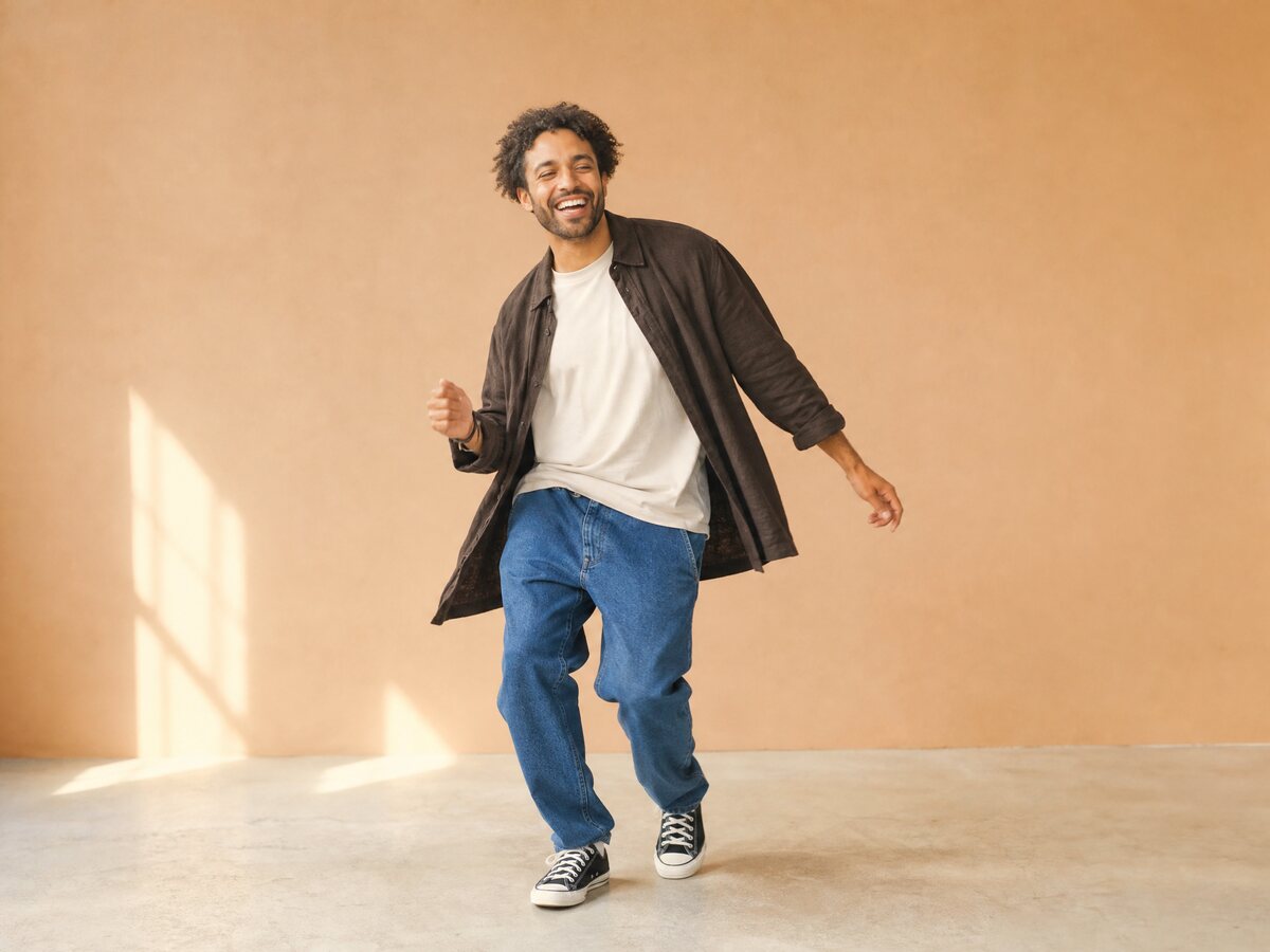 A person doing a simple two-step in a bright studio with a plain backdrop